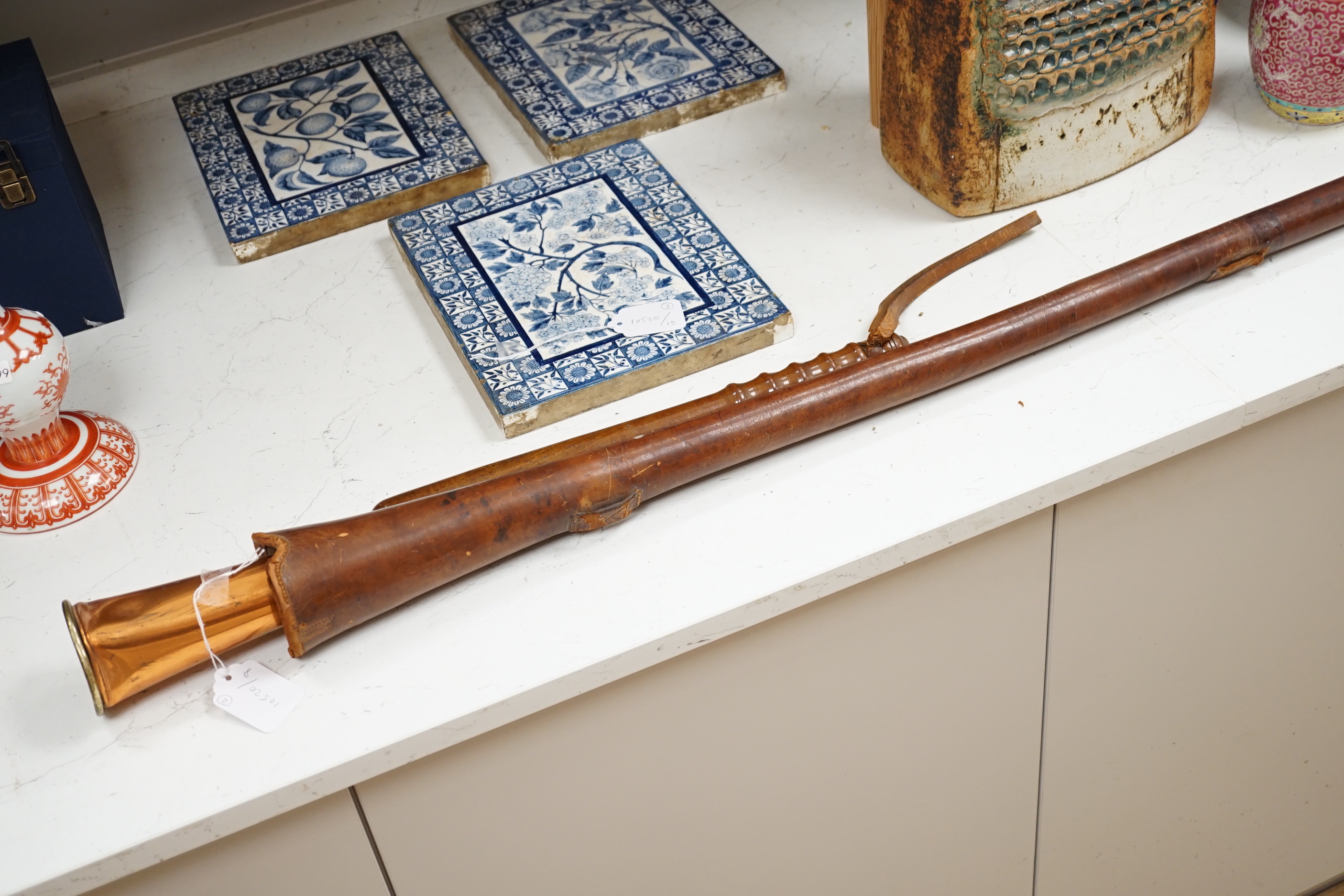 A copper hunting horn by Kohler & Son, a.f., in leather case and a turned wood truncheon, the largest 88cm in length